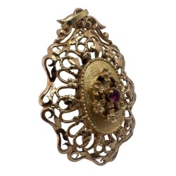 Pendentif médaillon en or jaune 750 millièmes (18K) à décor de fleurs, la centrale sertie d'un rubis 0,15cts environ, entourage 