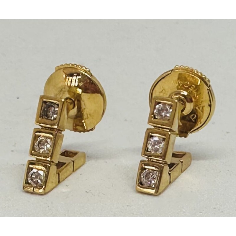 Paire de clous d'oreille en or jaune 750 millièmes (18K) serti en clos d'une ligne de trois diamants en brillant 0,05 cts chacun