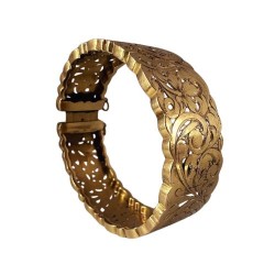 Bracelet manchette en or jaune 750 millièmes (18K) à décor ciselé et ajouré de feuilles stylisées. Fermoir à cliquet (chaînette 