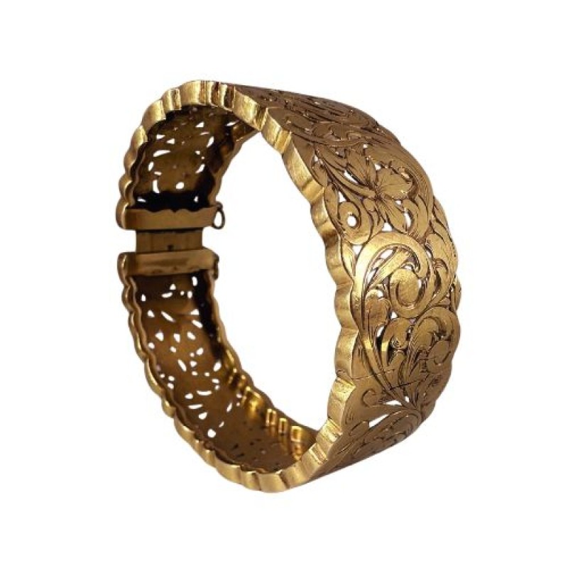 Bracelet manchette en or jaune 750 millièmes (18K) à décor ciselé et ajouré de feuilles stylisées. Fermoir à cliquet (chaînette 