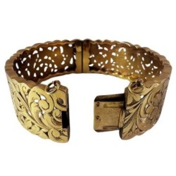 Bracelet manchette en or jaune 750 millièmes (18K) à décor ciselé et ajouré de feuilles stylisées. Fermoir à cliquet (chaînette 