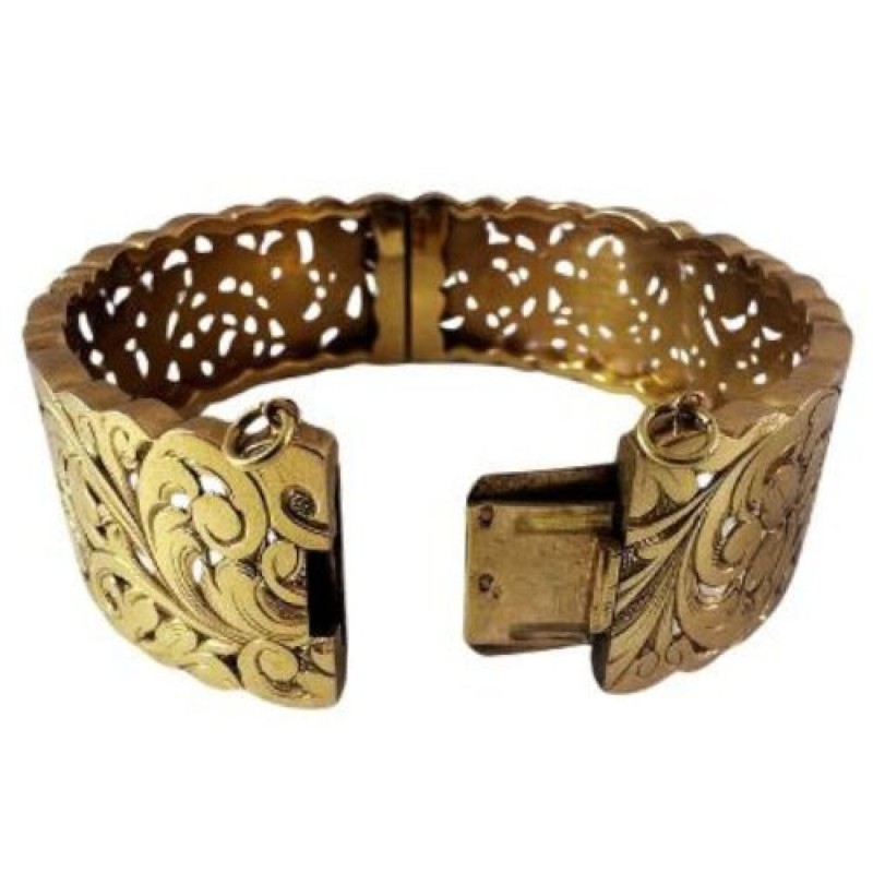 Bracelet manchette en or jaune 750 millièmes (18K) à décor ciselé et ajouré de feuilles stylisées. Fermoir à cliquet (chaînette 