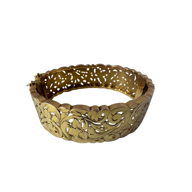 Bracelet manchette en or jaune 750 millièmes (18K) à décor ciselé et ajouré de feuilles stylisées. Fermoir à cliquet (chaînette 