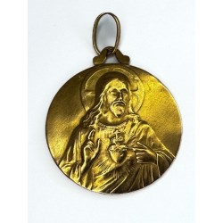 Médaillon en or jaune 750 millièmes (18K) à décor en relief à l'effigie de la Vierge à l'enfant à l'avers, et du Christ au sacré