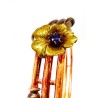 Bracelet rigide en or jaune nuancé 750 millièmes (18K) à enroulement tubulaire. Il est surmonté d'une fleur sertie d'une pierre 