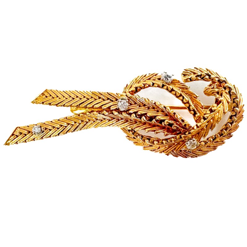 Broche noeud en or jaune 750 millièmes (18K) à maille tressée sertie de quatre diamants en brillant 0,07cts chacun environ. Poid